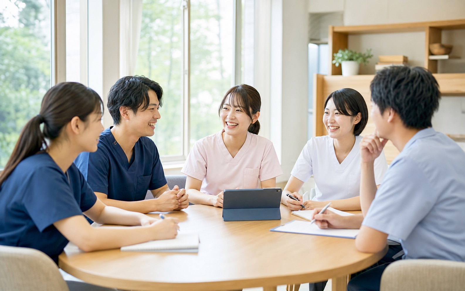 訪問看護ステーションのスタッフが笑顔で語り合う様子